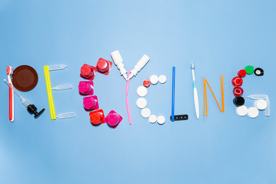 The word recycling composed with various plastic garbage items on colorful background