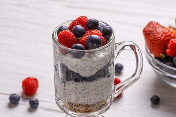 Muesli with berries and chia seeds on a light marble table