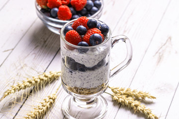 Muesli with berries and chia seeds on a light marble table