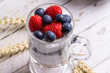 Muesli with berries and chia seeds on a light marble table