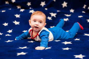 
little boy lies on a blue background with stars