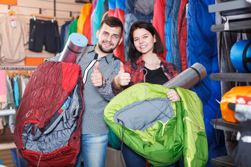 Couple examining touristic equipment items