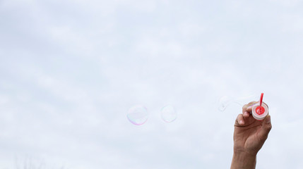 Soap bubbles in the hands. Sunny day spring. Outdoor.