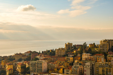Elevated, scenic view of the coastal city of Sanremo with a cloudy sky over the sea in the...