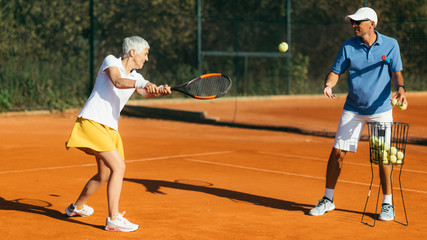 Active Senior Woman Practicing Tennis