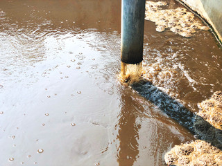 Metal pipeline of Sludge treatment in wastewater management system, Water treatment tube flowing brown smelly liquid and drying, made for fertilization can use in agriculture field. Selective focus.