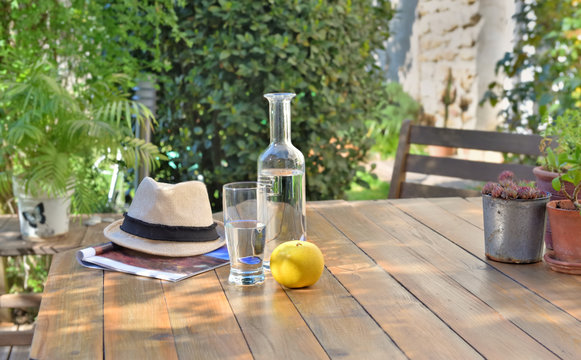 close on water drink and apple on a wooden table in garden  of a country house
