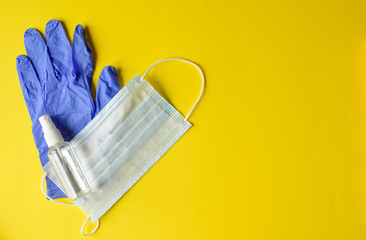 .Coronavirus, medical gloves, medical mask, antiseptic on a yellow paper background
