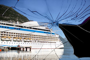 Naklejka premium broken mirror with cracks - the concept of a failed vacation, canceled trip, spoiled vacation, disaster, quarantine, isolation. beautiful cruise ship, floating on the sea, fjord