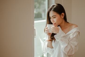 Young woman asia wake up refreshed in the morning and relaxing eat coffee, cornflakes, bread and apple for breakfast at house on holiday. Asian, asia, relax, breakfast, refresh, lifestyle concept.