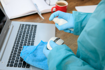 COVID-19 Coronavirusdisinfection of workspace cleaning disinfecting wipes to wipe surface of desk, keyboard, mouse at office. Stop the spread of corona virus