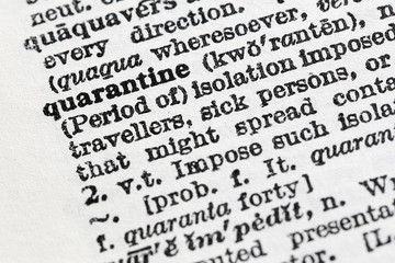 Quarantine - Closeup macro of English dictionary page with word quarantine