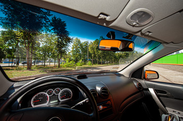 view from the car of the city landscape, rear-view steering wheel mirrors and dashboard.