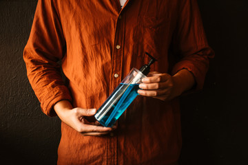 Man hands holding alcohol sanitizer gel for protecting infection from a corona virus and other viruses.