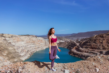 Fototapeta na wymiar Young woman is practicing yoga at mountain lake