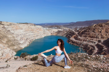 Fototapeta na wymiar Young beautiful woman is practicing yoga at mountain lake