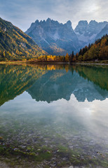 Autumn peaceful alpine lake Durrensee or Lago di Landro.  Snow-capped Cristallo rocky mountain group behind, Dolomites, Italy, Europe. Picturesque traveling, seasonal and nature beauty concept scene.