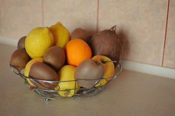 Different tropic fruits in a bowl on a table. Helathy food against diseases