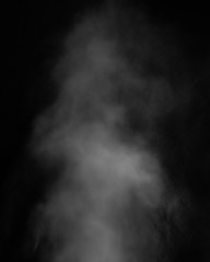 White clouds of smoke vapor isolated on a black background. The magic effect of foggy dust, which...