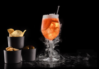 Beautiful cocktail isolated on black background with dry ice smoke.