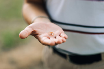 A man holds an engagement ring in his palm. Offers hands and hearts.
