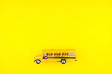 School bus toy yellow on a yellow background.