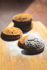 oatmeal cookies on a wooden board sprinkled with powdered sugar, toned