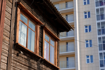 Old residential building on the background of a new tall house