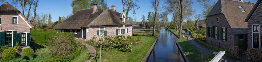 Fototapeta na wymiar Giethoorn Overijssel Netherlands. During Corona lock-down. Empty streets, paths, bridges and canals. Old farmhouse panorama