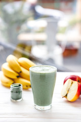 promotional shooting of a fruit cocktail for a healthy eating establishment. In the photo, a glass with a green drink made from fruits and algae spirulina powder