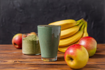 Smoothie with fresh red apple, banana and spirulina powder. Summer vitamin refreshing drink. Healthy detox diet