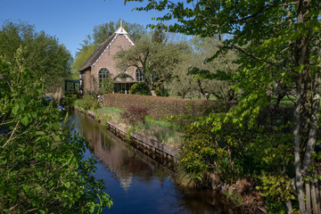 Fototapeta na wymiar Giethoorn Overijssel Netherlands. During Corona lock-down. Empty streets, paths, bridges and canals. Old church building turned into a house.