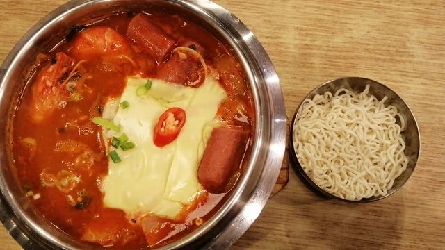 Korean Hot pot spicy Budae Jjigae with sausage, vegetables, pork, prawn, tofu and cheese