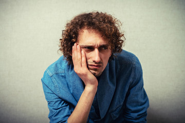 curly-haired man leaned his chin on hand