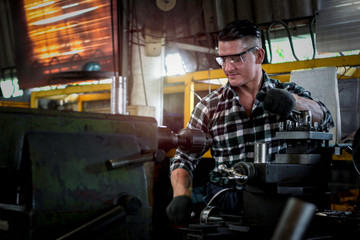 Fototapeta na wymiar Industrial engineer worker wearing safe glasses, operating with machinery at manufacturing plant factory, working with machine in industry concept