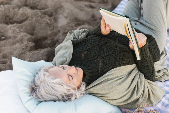 Senior Woman Reading Book Outdoors