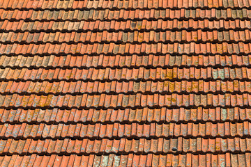 Texture of orange clay roof tiles. Red old dirty roof. Old roof tiles. Construction equipment build a house.