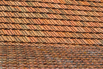 Texture of orange clay roof tiles at different angles. Red old dirty roof. Old roof tiles. Construction equipment build a house.