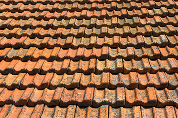 Texture of orange clay roof tiles. Red old dirty roof. Old roof tiles. Construction equipment build a house.