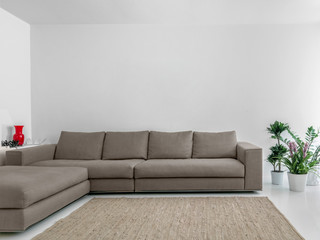 close-up of a fabric sofa and its carpet in the modern living room whose walls are colored white