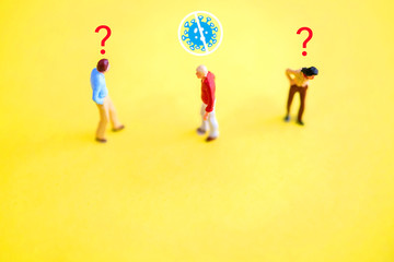 Miniature figure of a man who clean from infection of pandemic corona virus or covid-19 on blue background, unknown suspicious people with question marks.Social distancing concept