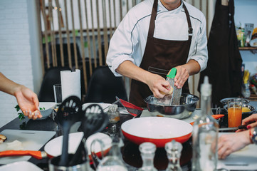 Chef grating cheese, chef hand grating parmesan cheese with grater, Chef rubbing cheese on a grater, close up