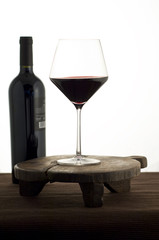 Calice di vino rosso con bottiglia,  su fondo bianco