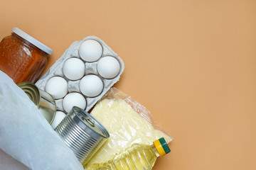Different food in bag on red background, close up. Grocery shopping concept, top view