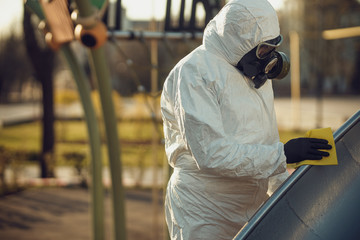 Cleaning and Disinfection on the playground in the sity complex amid the coronavirus epidemic Teams for disinfection efforts Infection prevention and control of epidemic Protective suit and mask