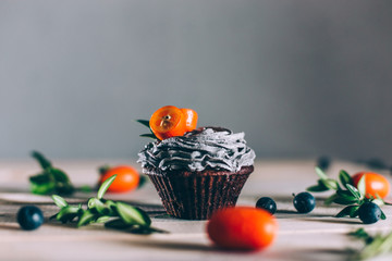 Chocolate muffin with airy blueberry cream, decorated with kumquat on top