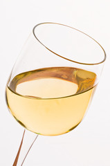 Vino bianco in calice su fondo bianco