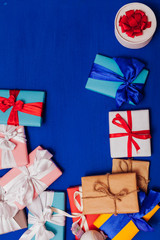 many multi-colored gifts for the holiday on a blue background