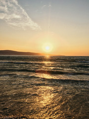 the rays of the rising sun are reflected in the sea in summer