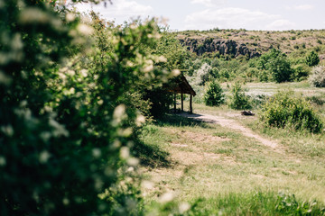 A gazebo on a wide valley with a river. Background of stone slopes. Aktyev canyons, natural national park.